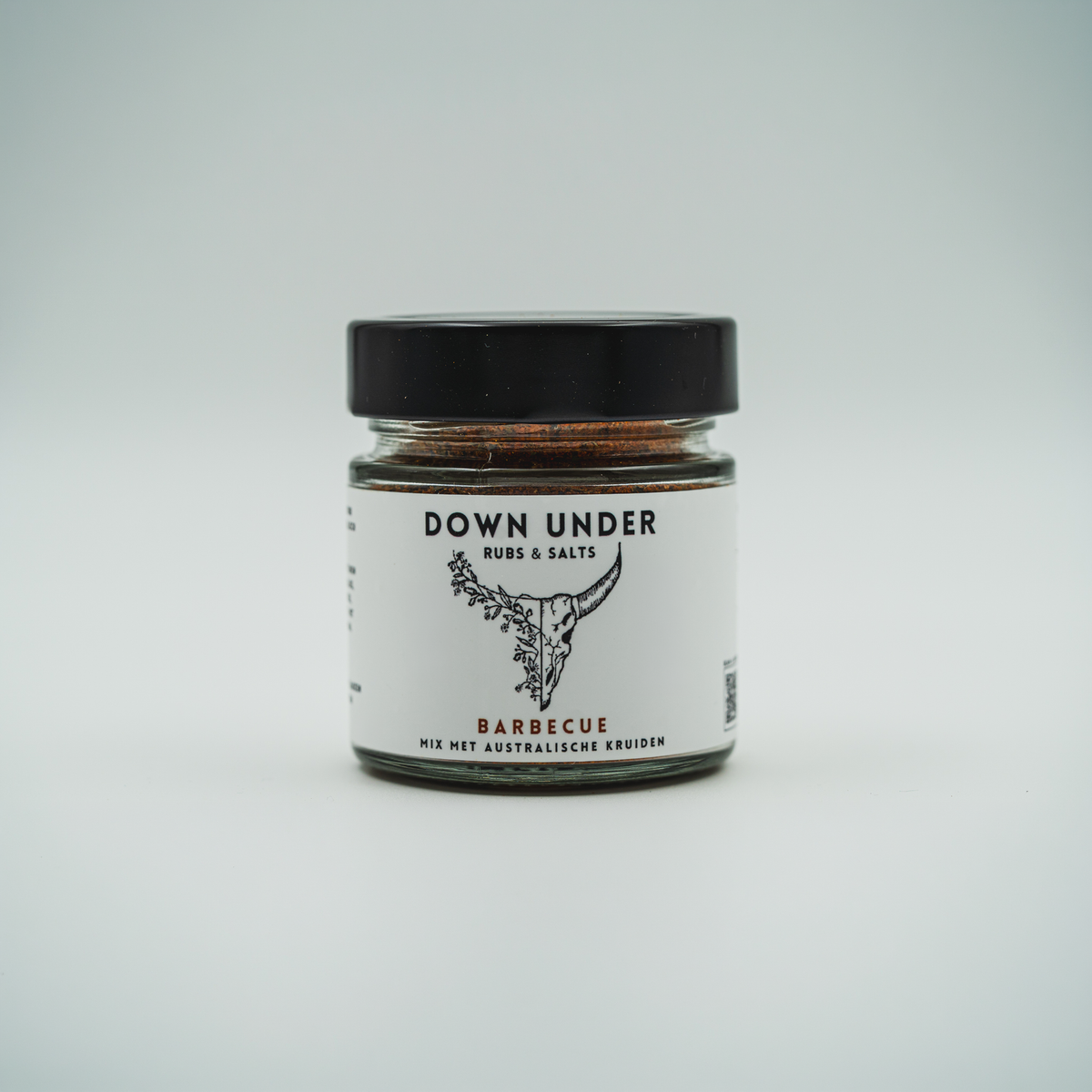 Standaard productfoto van een dicht glazen potje Barbecue Rub van Down Under Rubs op een lichte ondergrond.