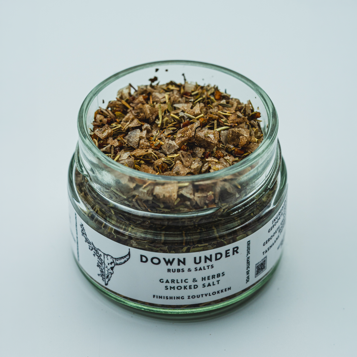 Geopend glazen potje Garlic & Herbs Smoked Salt kruidenmix met zicht op de knoflook en groene kruiden.